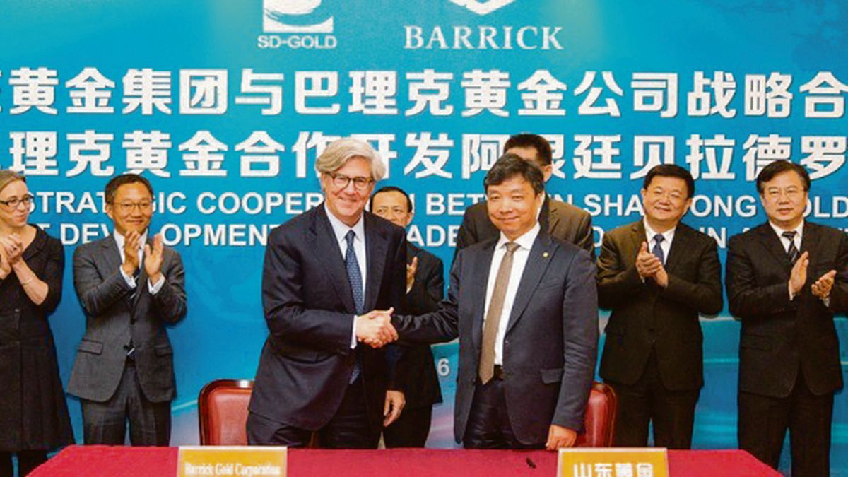 Presidentes de Barrick Gold y Shandong Gold estrechando manos en la firma del acuerdo por la mina Veladero, San Juan.