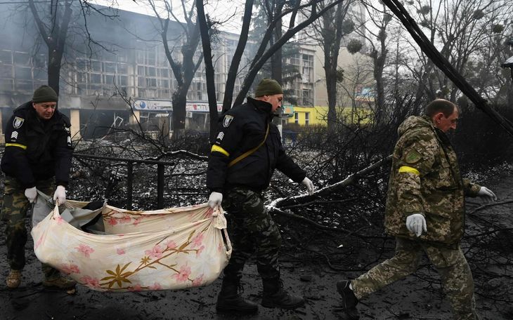 Servicios de emergencias ucranianos trasladan un cuerpo.