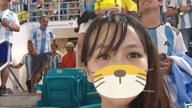 La joven china, y el hincha argentino detrás de ella, en plena Copa América