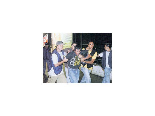 La Policía traslada a uno de los cincuenta detenidos momentos antes de que los Rolling Stones se presenten en el estadio de River Plate. Hubo destrozos y más de 15 heridos.