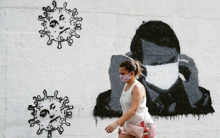 ÍCONO. La conocida imagen de Jair Bolsonaro luchando para colocarse con un tapaboca ya es graffiti en los muros de Río de Janeiro.