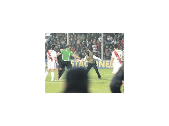 Los barras bravas quisieron ser protagonistas suspendiendo por 20 minutos el partido. Pitana protege a los jugadores de River. Abajo, el festejo de César Pereyra y la mueca triste de Carrizo.