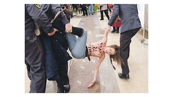 Una manifestante ucraniana anti-Putin fue arrestada poco después de que el candidato oficialista emitiera su voto en Moscú.