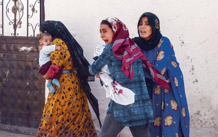 Pánico. Un grupo de mujeres turcas huyen con sus bebés en brazos tras un bombardeo en la ciudad fronteriza de Akcakale.