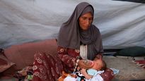 Una abuela alimenta a su nieta con agua colada de sopa en una tienda improvisada de Gaza. No hay leche ni fórmula, solo desesperación.