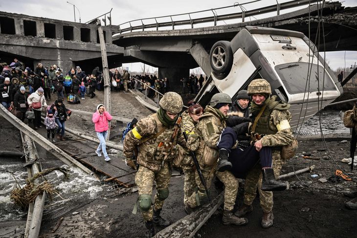Soldados ucranianos socorren a civiles que trataban de huir de Irpin, en las afueras de Kiev.
