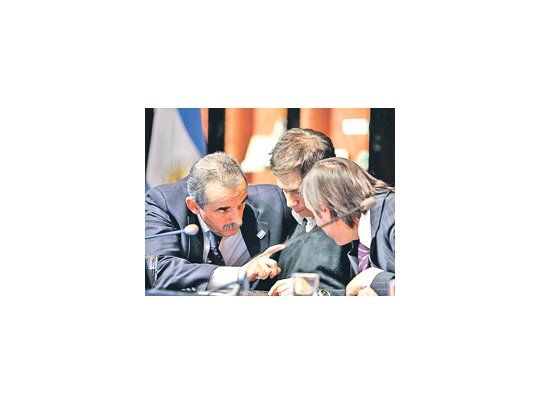 Parecería la primera línea de un scrum, pero son Guillermo Moreno, Axel Kicillof y Hernán Lorenzino  definiendo la postura oficial en medio de los anuncios efectuados en un salón del edificio central de la AFIP.