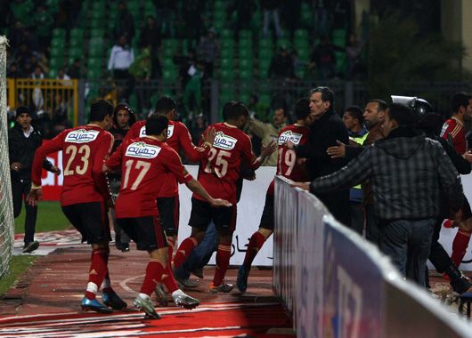 Los jugadores de Al-Ahly intentan escapar del caos en la cancha.