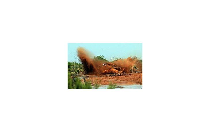 ámbito.com | La aventura en todos los colores. Un auto cruza a toda velocidad el charco y llena de colores la escenografía. Una de las tantas bellezas que nos regaló este Dakar 2011.