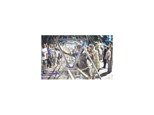 Un soldado controla una de las vallas frente a la Suprema Corte Constitucional en El Cairo luego de las protestas que ya han dejado  al menos 830 fallecidos en cuatro días por la brutal represión de las Fuerzas Armadas.