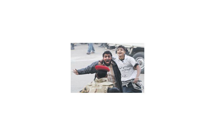 ámbito.com | Dos manifestantes protestan luego de que soldados del Ejército intentaran detenerlos en la céntrica plaza Tahrir. Está por verse cómo se resolverá la relación con los militares de quienes reclamaban democracia.