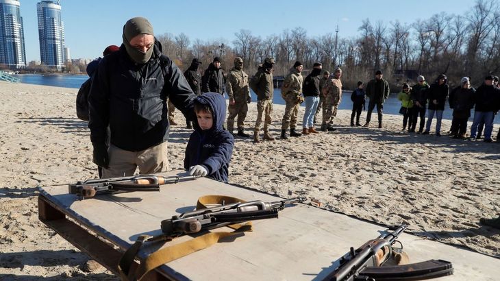 Un niño toca un arma durante un entrenamiento militar de civiles en Kiev.