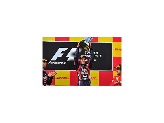 Sebastian Vettel levanta el trofeo en Turquía. Mark Webber y Fernando Alonso lo miran y aplauden.