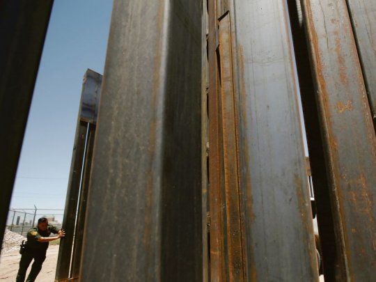 Separación. Un agente de frontera de EE.UU. cierra una sección del muro que separa a ese país de México, en El Paso. Donald Trump quiere extender la barrera a todo el límite. Y ahora lo ayudan ciudadanos comunes.