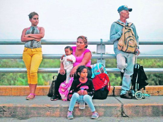 DESCANSO. Una familia de venezolanos reposa unos instantes en el puente Simón Bolívar que une el país con Colombia.