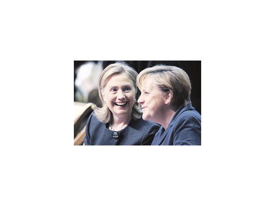 Hillary Clinton sonríe mientras dialoga con la jefa de Gobierno alemana, Angela Merkel, en el inicio de la cumbre de la Organización para la Cooperación y el Desarrollo en Europa, en Astaná, Kazajistán. El Wiki-escándalo dominó la cita.