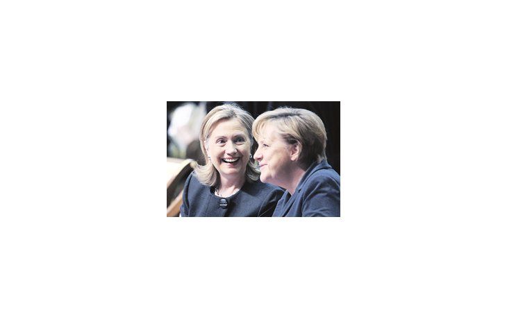 Hillary Clinton sonríe mientras dialoga con la jefa de Gobierno alemana, Angela Merkel, en el inicio de la cumbre de la Organización para la Cooperación y el Desarrollo en Europa, en Astaná, Kazajistán. El Wiki-escándalo dominó la cita.