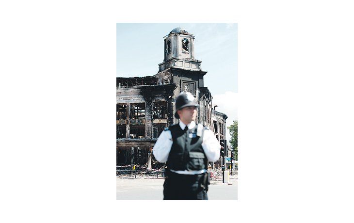 ámbito.com | Un policía apostado ayer frente a uno de los edificios incendiados la noche del sábado.