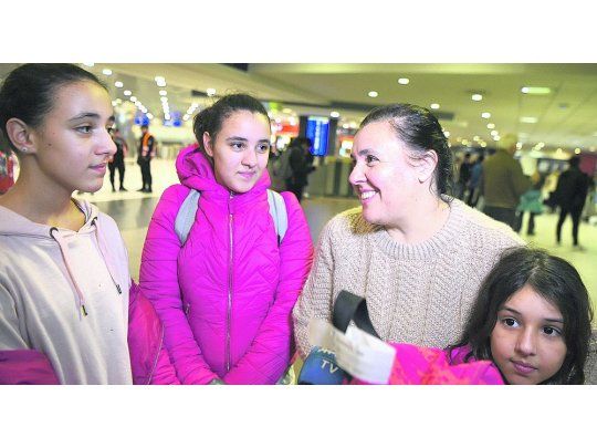 Felices. Valeria Marsilli, junto a las mellizas Renata y Bernardita (de 13 años) y Emilia (de 8), llegaron durante la madrugada a Ezeiza.