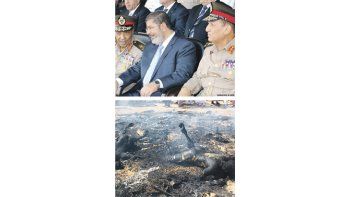 El presidente islamista de Egipto, Mohamed Mursi (centro), en una foto reciente junto al número uno y al número dos de las FF.AA., mariscal Husein Tantaui y Sami Anan, ayer defenestrados (arriba). Dos cuerpos carbonizados de presuntos terroristas son exhibidos por militares en el Sinaí, donde se realiza un despliegue de seguridad sin precedente (abajo).