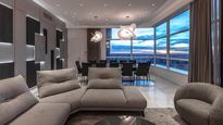 Amplio living con ventanales de piso a techo y vistas abiertas al skyline, en un penthouse que combina diseño contemporáneo, doble altura y terminaciones de alta gama