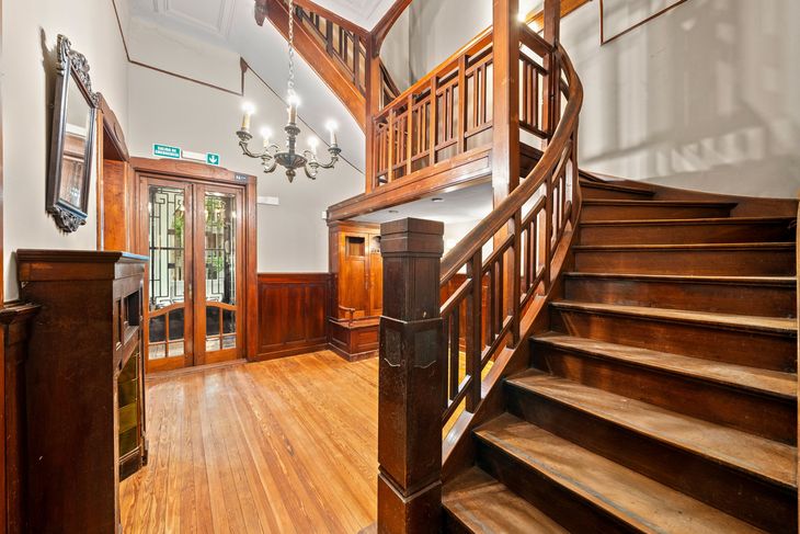 El hall con vitraux en la puerta que sale al exterior y la escalera de madera maciza El hall con vitraux en la puerta que sale al exterior y la escalera de madera maciza