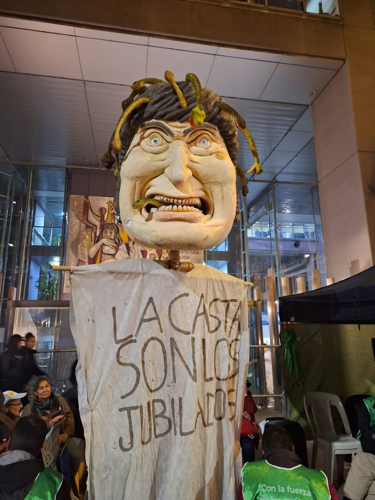 Jubilados protestan contra la ley Bases frente al Congreso con un muñeco de Javier Milei. 