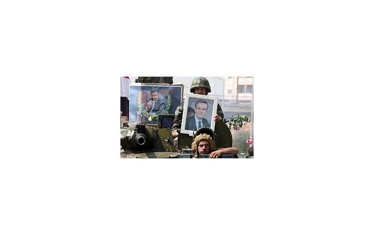 Soldados del régimen siria exponen retratos del presidente Bashar al Asad.