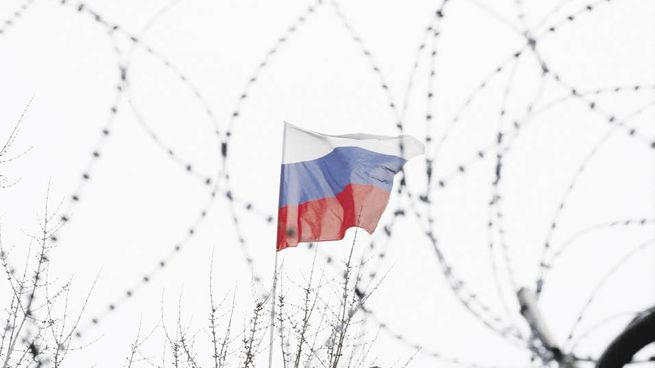 Una bandera rusa asoma tras la frontera de Ucrania. Los cruces entre EE.UU. y la UE por un lado, y Rusia por el otro, han ido escalando a pesar de los esfuerzos diplomáticos por contener daños mayores.