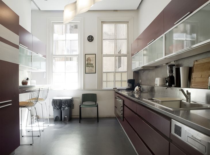 Cocina principal reciclada con diseño funcional y líneas contemporáneas, que conserva las proporciones originales del ambiente y la iluminación natural a través de carpinterías de época Cocina principal reciclada con diseño funcional y líneas contemporáneas, que conserva las proporciones originales del ambiente y la iluminación natural a través de carpinterías de época