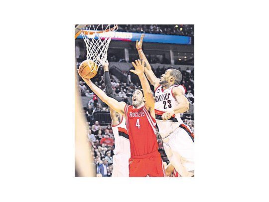 Luis Scola encesta ante la marcación de Marcus Camby. El argentino fue el goleador de los Rockets en el triunfo de su equipo ante Portland.