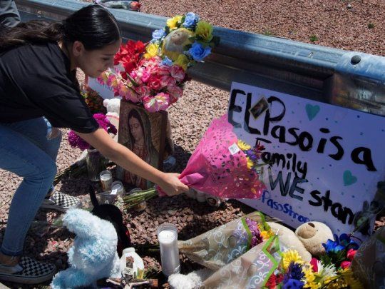 Una mujer deja flores en homenaje a las víctimas del tiroteo de El Paso.