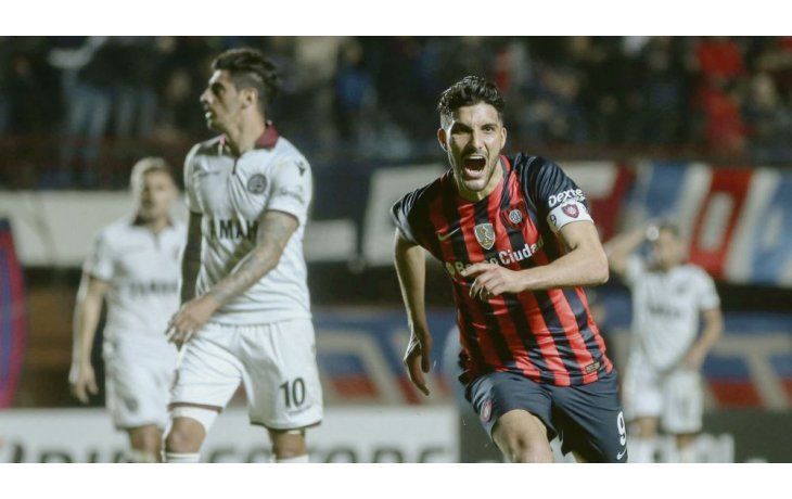 El goleador. Nicolás Blandi festeja ante la desazón de Román Martínez. San Lorenzo le ganó 2 a 0 a Lanús.