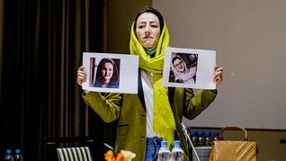 Heda Khamoush, delegada de la sociedad civil afgana para conversar con diplomáticos occidentales, sostiene fotos de las activistas desaparecidas.