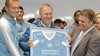 Aires de triunfo. Schiaretti, ayer junto al plantel de Estudiantes de Río Cuarto, que viene de celebrar su promoción a la Primera B Nacional. Hoy innovará con un cierre de campaña en la localidad rural de Rayo Cortado.&nbsp; 