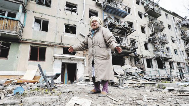 DESTRUCCIÓN. Una mujer camina delante de un edificio residencial en Mariúpol, una de las ciudades ucranianas más asediadas por Rusia. Si el Kremlin la toma, le quitaría otro puerto de relevancia a Ucrania, que ya perdió el de Crimea en 2014.