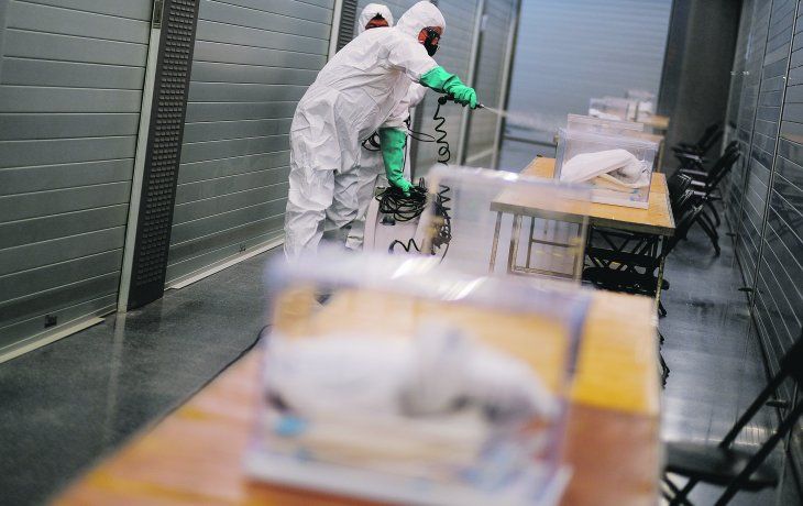 PROTOCOLO. Las elecciones se llevaron a cabo en medio de un fuerte operativo de seguridad sanitaria. Un grupo de trabajadores desinfecta las urnas en Barcelona.