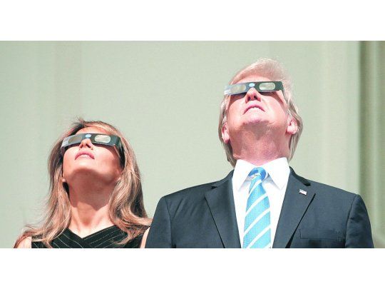 Vista presidencial. Trump salió a un balcón de la Casa Blanca junto con su esposa a observar el eclipse, que en Washington pudo verse en un 81%.