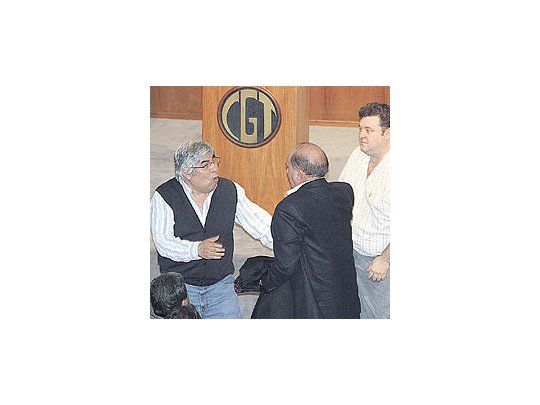 Hugo Moyano conversa con José María Díaz Bancalari, mientras sentado de espalda escucha Hugo Curto, ayer en la CGT. Fueron horas frenéticas de negociación.