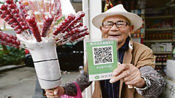 postal. Un recorte plastificado con un código QR para el pago virtual en una venta callejera. En grandes ciudades chinas y en el interior también.