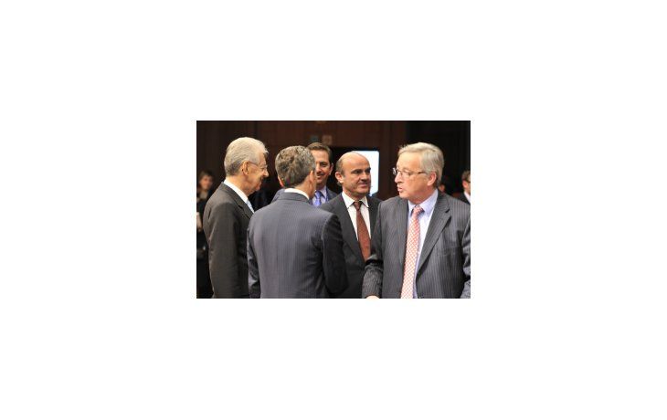 El presidente del Eurogrupo, Jean-Claude Juncker, (a la derecha) y a su espalda el ministro español de Economía y Competitividad, Luis de Guindos.