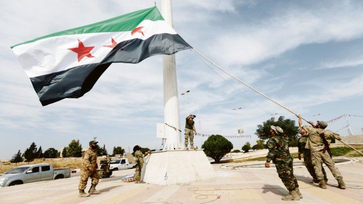 CONQUISTA. Rebeldes sirios que apoyan la ofensiva turca izan su propia bandera en Tel Abyad, hasta ayer territorio kurdo en Siria. Muchos de los grupos que combaten contra Al Asad tienen vínculos con el terrorismo islamista. CONQUISTA. Rebeldes sirios que apoyan la ofensiva turca izan su propia bandera en Tel Abyad, hasta ayer territorio kurdo en Siria. Muchos de los grupos que combaten contra Al Asad tienen vínculos con el terrorismo islamista.