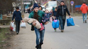 Tiszabecs, Hungría, una joven refugiada carga sus hijos después de verse obligada a dejar atrás a su esposo cuando huía de Ucrania.