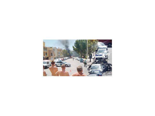 Un grupo de turistas observa atónito el lugar del atentado, ubicado en las cercanías de la playa Palmanova, Palma de Mallorca. La explosión fue impactante, con llamas, y el vehículo saltando por los aires, relataron testigos.
