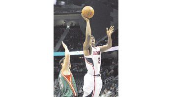 Joe Johnson se eleva y encesta ante la marca de Carlos Delfino. El argentino marcó 13 puntos en la derrota de los Bucks.
